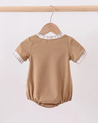 Brown baby romper with plaid trim on a hanger against a white background