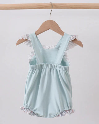 Light blue romper with floral details on a wooden hanger against a white background