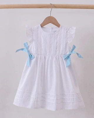 White dress with blue ribbons on a hanger against a plain background