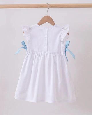 White dress with blue ribbons on a hanger against a white background