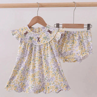 Floral baby outfit with top and shorts on hangers against a plain background