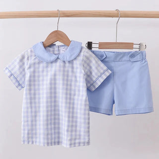 Children's outfit with checkered shirt and shorts on hangers against a white background