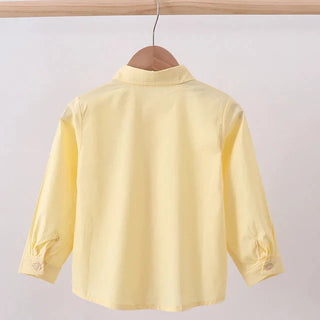Yellow shirt on a hanger against a white background