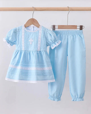 Light blue children's outfit with top and pants on hangers against a light gray background