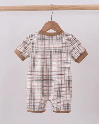 Plaid baby romper on a wooden hanger against a white background