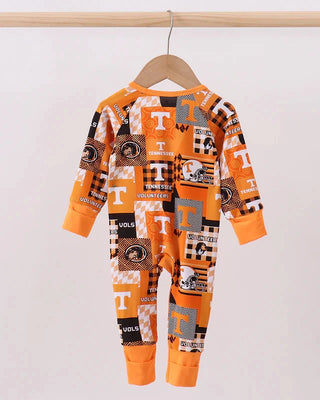 Orange and black patterned baby onesie on a hanger against a white background