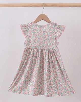 Floral dress on a hanger against a plain background