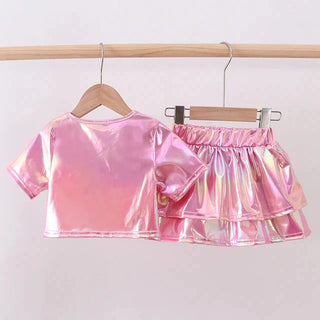Pink metallic top and skirt set on hangers against a white background