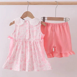 Pink lace dress and shorts set on hangers against a white background