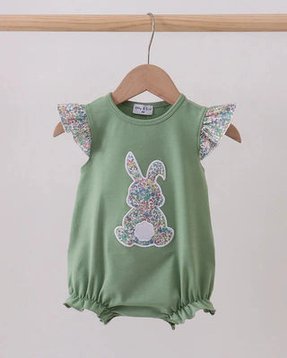Green baby romper with floral bunny design and ruffled sleeves on a wooden hanger against a white background.