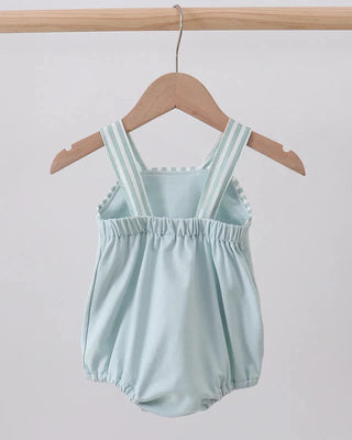 Light blue romper with striped straps on a wooden hanger against a plain background
