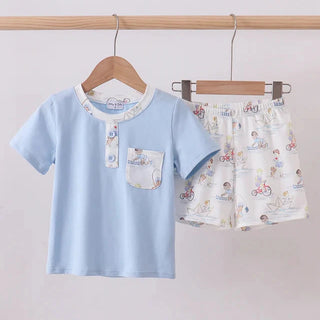 Children's blue shirt and patterned shorts hanging on a rack against a plain background