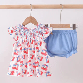 Baby’s  outfit with floral top and blue bloomers on a hanger against a white background