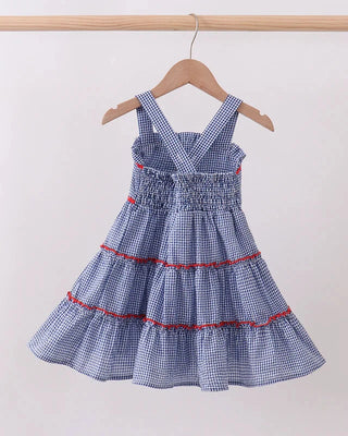 Blue checkered dress with red trim on a hanger against a white background