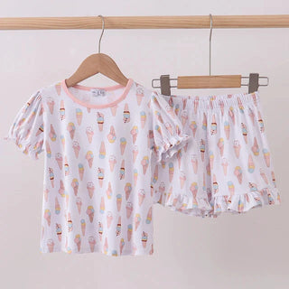 Children's pajama set with ice cream pattern on a hanger against a white background