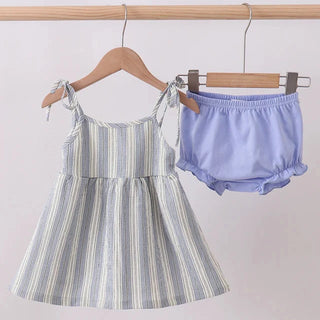Striped dress and light blue bloomers hanging on a rack against a white background