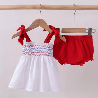 White top with red bloomers on hangers against a light background