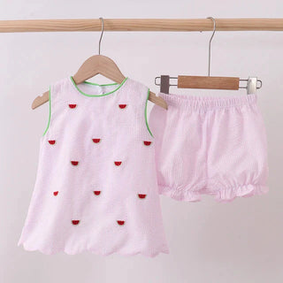 Pink girl’s outfit with watermelon details on a white background