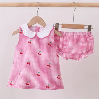 Pink checkered children's outfit with cherry design on a white background