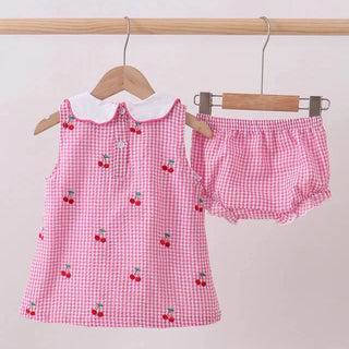 Pink checkered children's outfit with cherry pattern on a white background