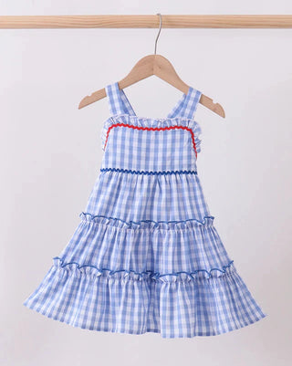 Blue checkered dress with red trim on a hanger against a white background
