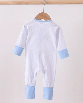 White baby onesie with blue accents hanging on a wooden hanger against a light background