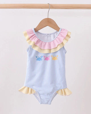 Baby romper with ruffled collar and colorful appliqués on a hanger against a white background