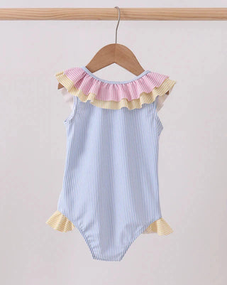 Striped baby romper with ruffled details on a wooden hanger against a light background