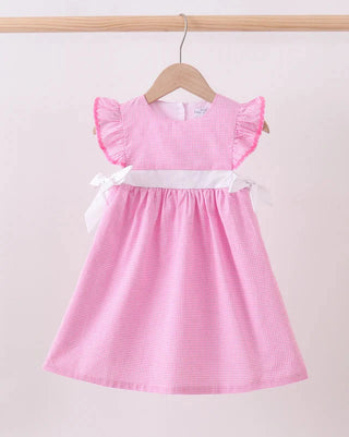 Pink checkered dress with ruffled sleeves on a hanger against a light pink background