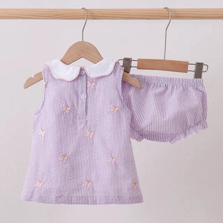 Purple striped dress with white collar and matching bloomers on hangers against a light gray background