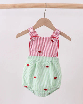 Red and green checkered baby romper with watermelon patterns on a wooden hanger against a white background