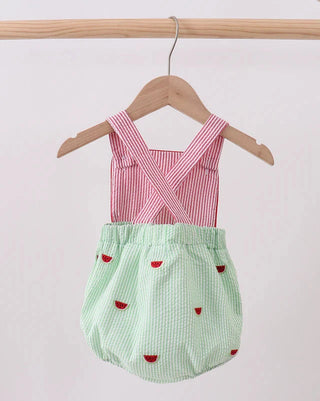 Baby romper with red top and green bottom on a hanger against a white background