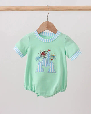 Light green baby romper with colorful castle design on a wooden hanger against a light gray background