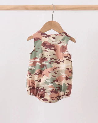 Camouflage-patterned baby romper on a wooden hanger against a white background