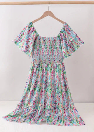 Floral dress on a hanger against a white background