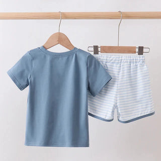 Children's blue t-shirt and striped shorts set hanging on a wooden rack against a white background
