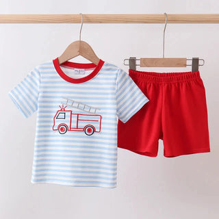 Children's outfit with striped shirt and red shorts on hangers against a white background