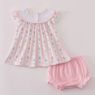 Baby dress and bloomers set with floral pattern on a light gray background