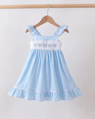 Light blue dress with bow details on a hanger against a white background