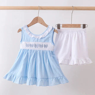 Light blue outfit with bow design and white shorts on hangers against a white background