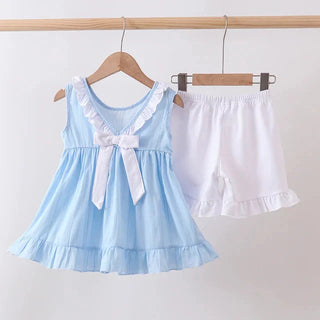 Light blue top with white ruffled shorts on hangers against a white background