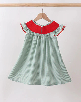 Green and red dress on a hanger against a white background