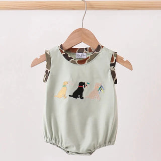 Light green baby romper with dog illustrations on a wooden hanger against a white background