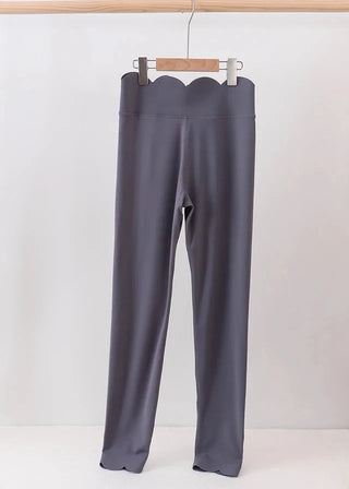 Gray leggings on a hanger against a white background