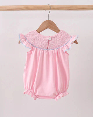 Pink baby romper with lace collar on a wooden hanger against a white background