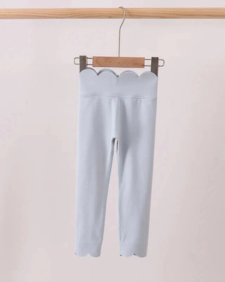 Light blue leggings hanging on a wooden hanger against a plain background