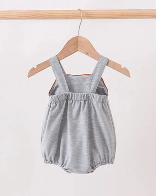 Gray baby romper with orange trim on a wooden hanger against a white background