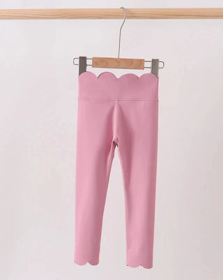 Pink leggings with scalloped hem on a hanger against a white background