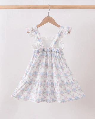 Floral dress hanging on a wooden hanger against a white background