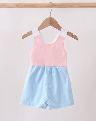 Two-tone pink and blue romper on a hanger against a light gray background